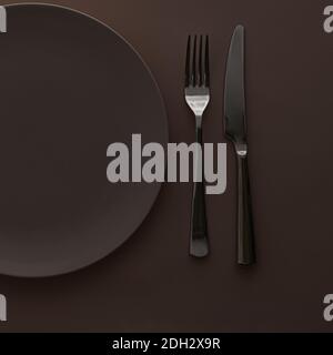 Empty plate and cutlery as mockup set on dark brown background, top tableware for chef table decor and menu branding Stock Photo