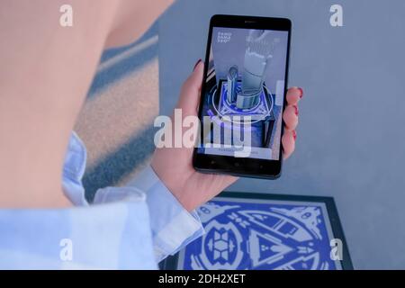 Woman using smartphone with architecture augmented reality app - AR concept Stock Photo