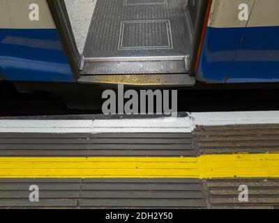A safety yellow and white line painted on a train platform. Stock Photo