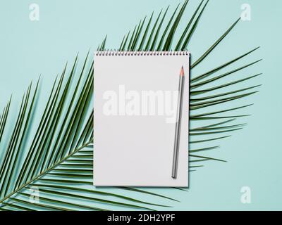 Blank paper notebook and tropical leaf Stock Photo