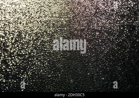 An abstract image of light reflecting off condensation on a window. Stock Photo
