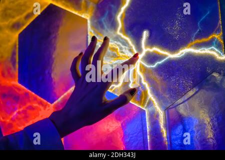 Woman hand touching plasma panel display in dark room of museum - close up view Stock Photo