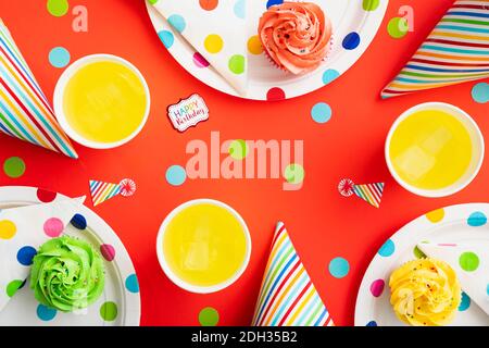 Colorful birthday celebration setup featuring cupcakes and drinks on a festive polka dot table Stock Photo