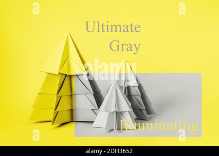 Simple origamy 3D Christmas tree made from paper toned yellow color. Yellow and Gray Colors as colors of 2021 year Stock Photo