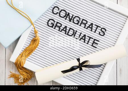 Celebrating graduation with a diploma, cap, and congratulatory message on display in a cozy setting Stock Photo