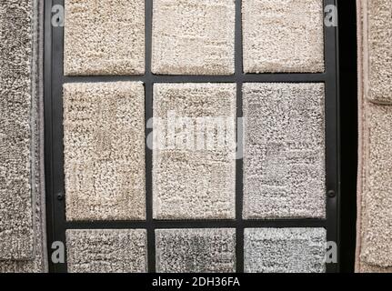 Various textures of decorative carpets displayed in a grid pattern in a home decor store Stock Photo
