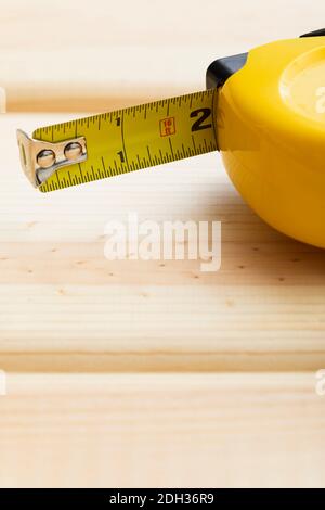 Measuring tools lay on wooden surface with tape visible in construction or DIY project setting Stock Photo