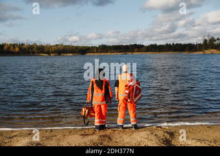 Two proud paramedics posing near blue lake on sunny day Stock Photo