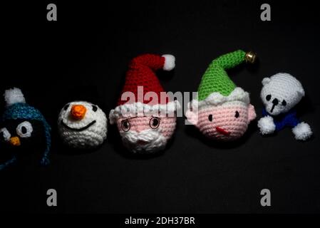 Portrait of Christmas Amigurumi crocheted or knitted stuffed toy on black background Stock Photo