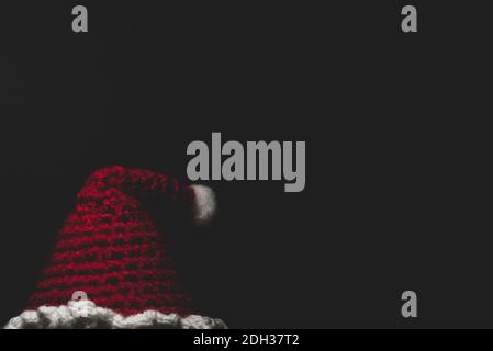 Portrait of Santa Claus Amigurumi crocheted or knitted stuffed toy on black background Stock Photo