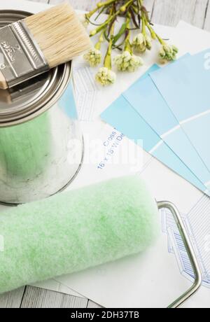 Materials for a home painting project with paint samples and tools on a wooden surface Stock Photo