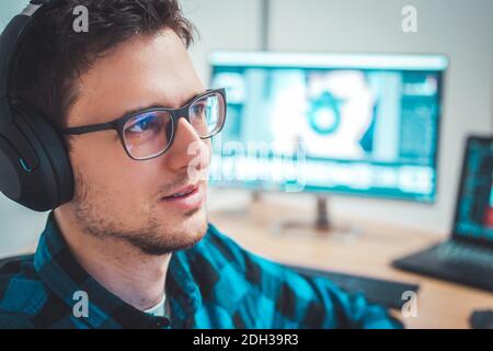 Young freelancer is sitting in his home office and working on a creative project Stock Photo