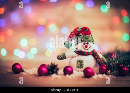 cheerful snowman in knit hat and Christmas decorations on festiv Stock Photo