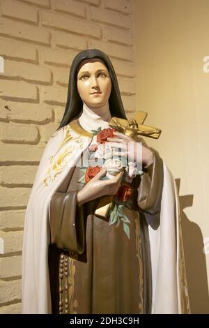 Woman Saint Sculpture Holding Cross Stock Photo