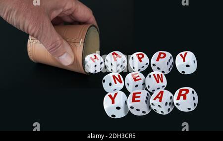 Dice spelling Happy New Year when tumbling out of a raffle cup hold by one hand on black background. Good luck and wealth concept. Stock Photo