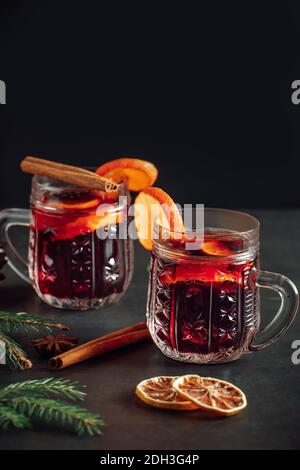 Hot mulled wine in a glass cup. Warm winter drink with spices and fruits. Stock Photo