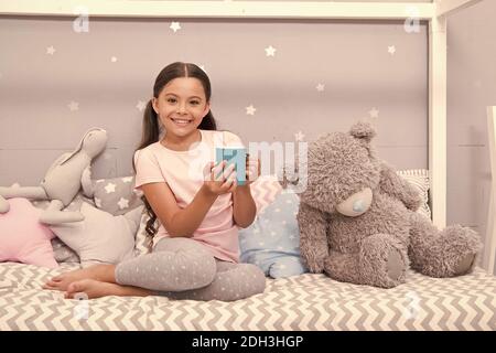 Hot milk before sleep. Health Benefits Drinking water before bed. Little child hold mug. Girl in pajamas drinking tea. Relaxation before sleep. Drinking milk just before bed. Bedtime beverage. Stock Photo