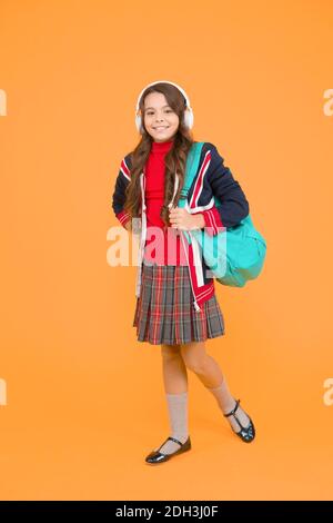 small girl headset with backpack. kid with english flag on jacket. study english language online. Improve your English with audio lessons. vacation in great britain. ebook and private lesson concept. Stock Photo