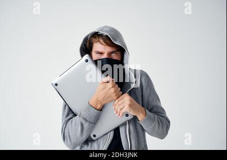 secretive masked man laptop hacker penetration danger Stock Photo