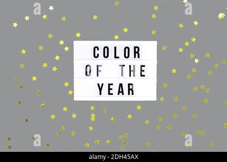 Retro lightbox with Color of the year wording on the trendy solid gray backdrop with festive yellow golden star shaped confetti, place for text Stock Photo