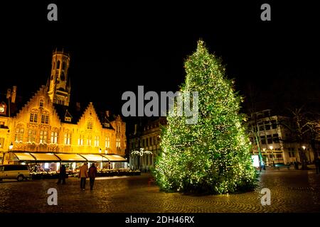 Christmas tree and Belfry tower of Bruges in Belgium. Festive illumination, magical winter time. Stock Photo