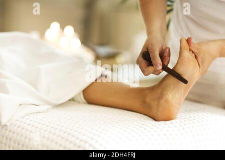 Crop masseuse making feet massage to client Stock Photo