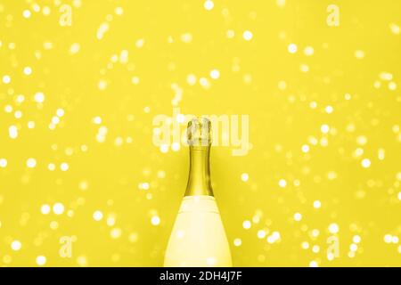 Champagne bottle on yellow background. Christmas, birthday, bachelorette or wedding concept. Flat lay style. Top view, copy space. color 2021 Stock Photo