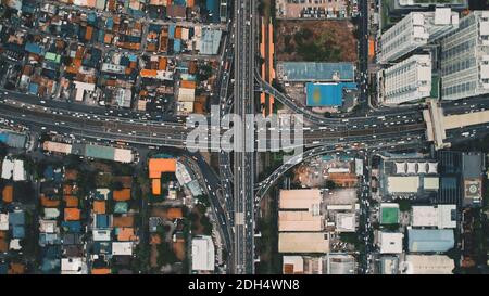 Top down of traffic cross highway at downtown aerial. Skyscrapers, buildings roofs of Philippines capital city of Manila cityscape. Scenic urban transportation: cars, buses at town road Stock Photo