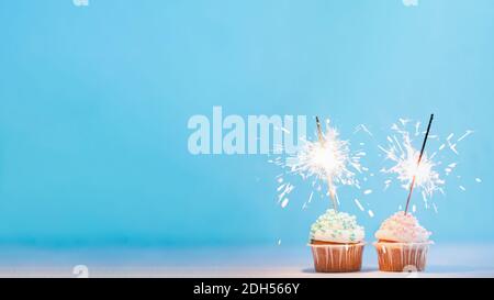 Two cupcakes decorated with sparklers, copy space Stock Photo