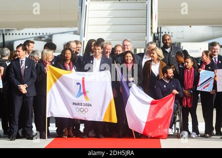 Paris Mayor Anne Hidalgo (C) poses with Paris 2024 Bid Co-Chair Tony Estanguet (5L) Ile-de-France regional president Valerie Pecresse (8R), Paris 2024 Bid Co-Chair Bernard Lapasset (C/R) French former Olympic champion, former politician and International Olympic Committee (IOC) member Guy Drut (C/L) French wheelchair tennis player Michael Jeremiasz (C/R) and President of The French Paralympic Committee Emmanuelle Assmann (C/L) and French Sport Minister Laura Flessel (4L), Teddy Riner after disembarking from an aircraft at Roissy-Charles de Gaulle Airport on the outskirts of Paris on September Stock Photo