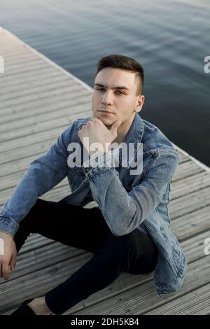 Calm man resting on wooden pier Stock Photo