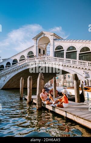 Couple men and woman on a city trip to Venice Italy, colorful streets with canals Venice Stock Photo
