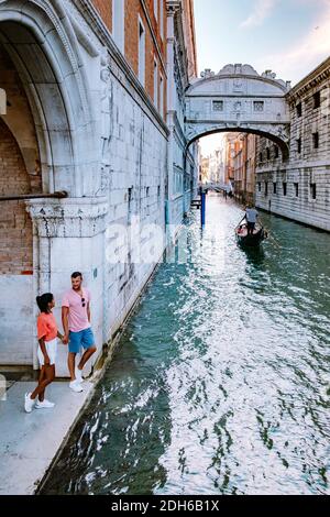 Couple men and woman on a city trip to Venice Italy, colorful streets with canals Venice Stock Photo