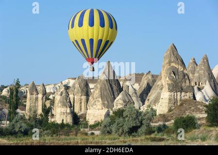 balloon over fairy chimneys, typical rock formation in Cappadocia, Turkey Stock Photo