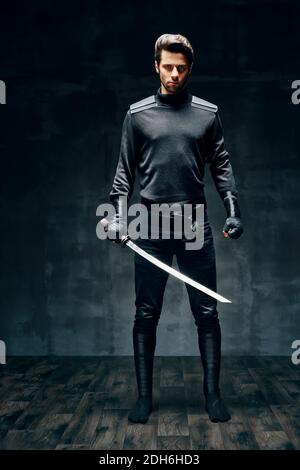 Full length portrait of warrior man posing with a sword Stock Photo