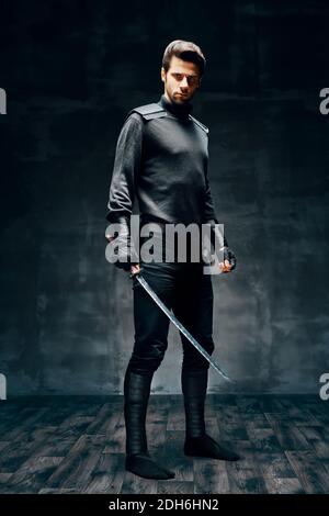 Full length portrait of warrior man posing with a sword Stock Photo