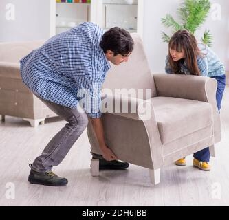 Man moving armchair in the living room Stock Photo