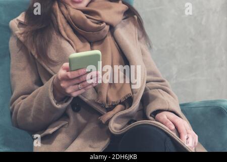 Woman using smartphone in lobby of modern office building Stock Photo