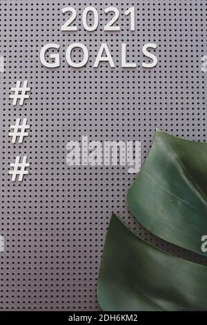 Goals 2021 concept. White text and numbers on a gray board. Monstera leaf, tropical theme Stock Photo