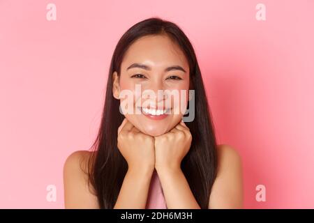 Beauty, fashion and lifestyle concept. Close-up of gorgeous happy asian girl, looking dreamy and delighted, leaning head on hand Stock Photo