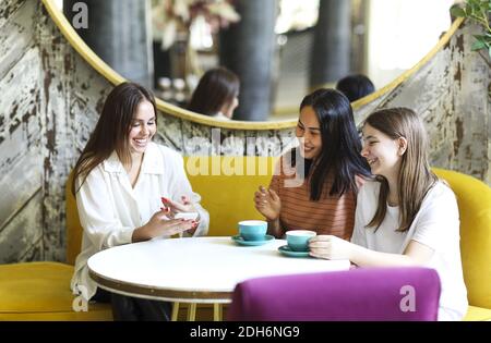 Happy multiethnic friends meeting in cafeteria Stock Photo