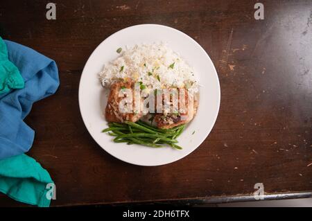 cripsy fried chicken thighs with vegetables over rice in a lemon sauce Stock Photo