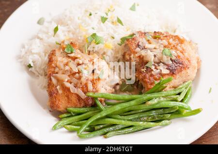 cripsy fried chicken thighs with vegetables over rice in a lemon sauce Stock Photo
