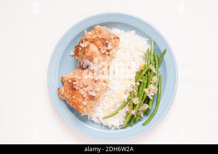 cripsy fried chicken thighs with vegetables over rice in a lemon sauce Stock Photo