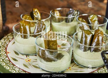 Dolma, stuffed cabbage rolls in grape leaves in sauce. Stock Photo