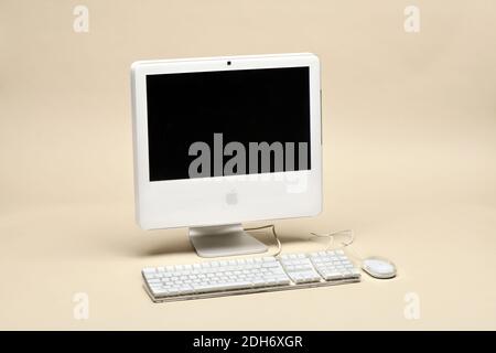 Apple iMac 17 inches 2006 with keyboard and mouse isolated on beige background. First Apple computer with Intel CPU Stock Photo