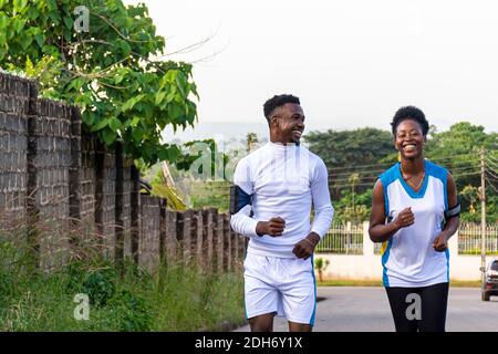 two young african man and woman smiling while jogging Stock Photo