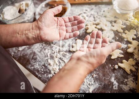 Hands of experienced baker being covered in flour Stock Photo