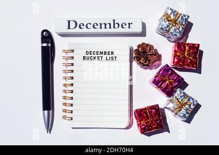 December bucket list written on notepad with Christmas decorations background. Merry Christmas concept Stock Photo