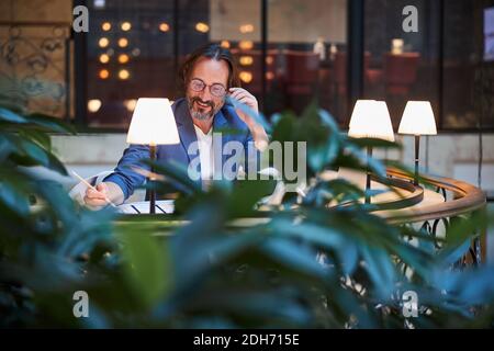 Focused optimistic man doing his work from a comfortable lounge Stock Photo